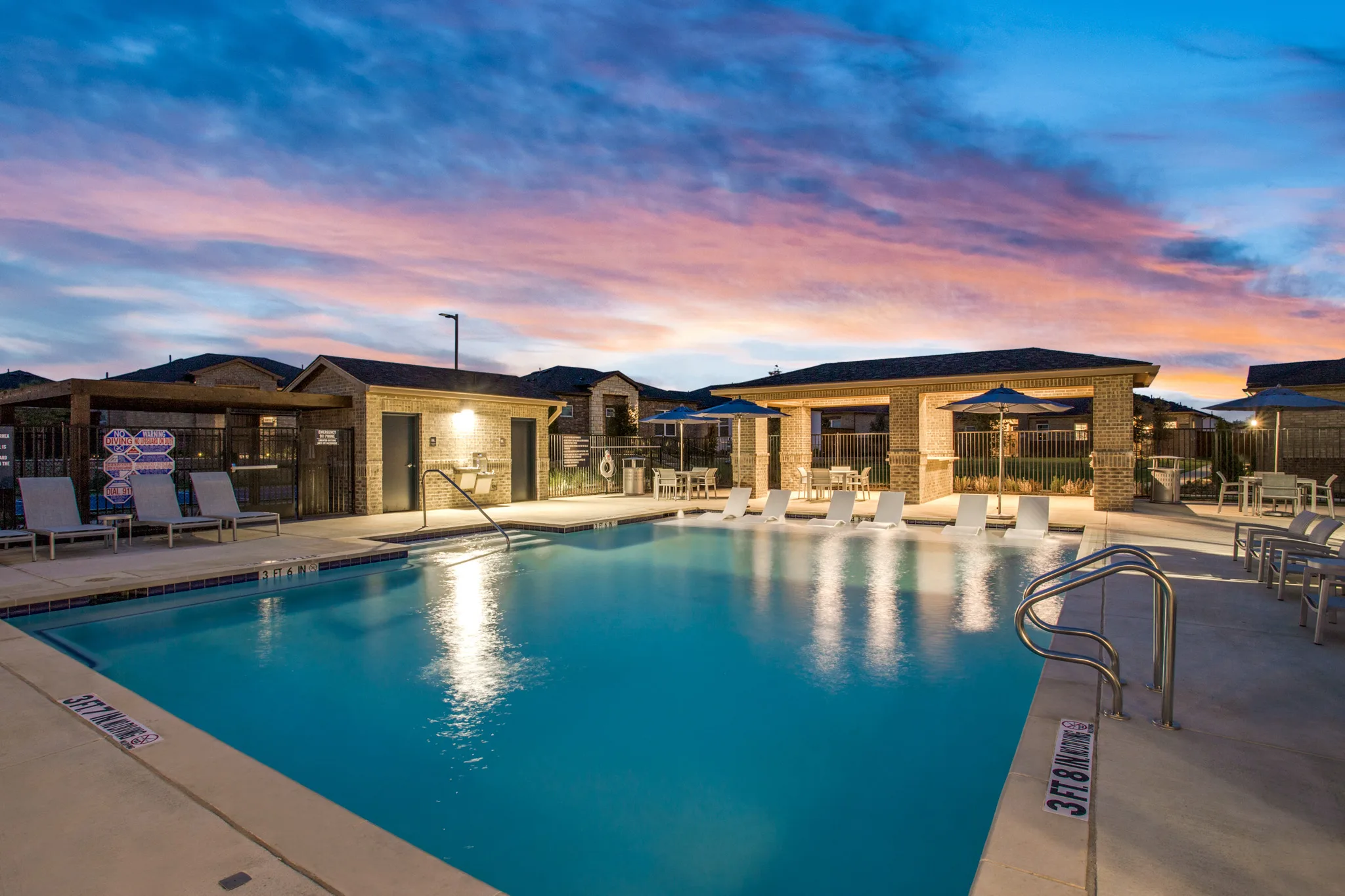 Twilight picture of pool and ramada beside the pool.